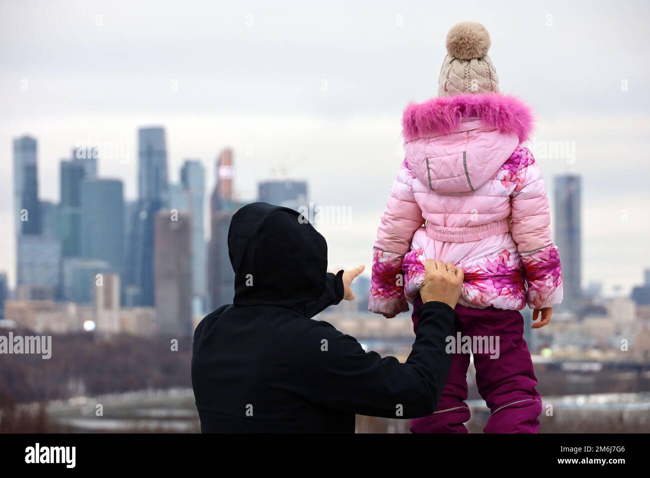 Homme avec enfant regardant le panorama et les gratte-ciels de la ville de Moscou. Voyage d'hiver en Russie ou achat immobilier Banque D'Images