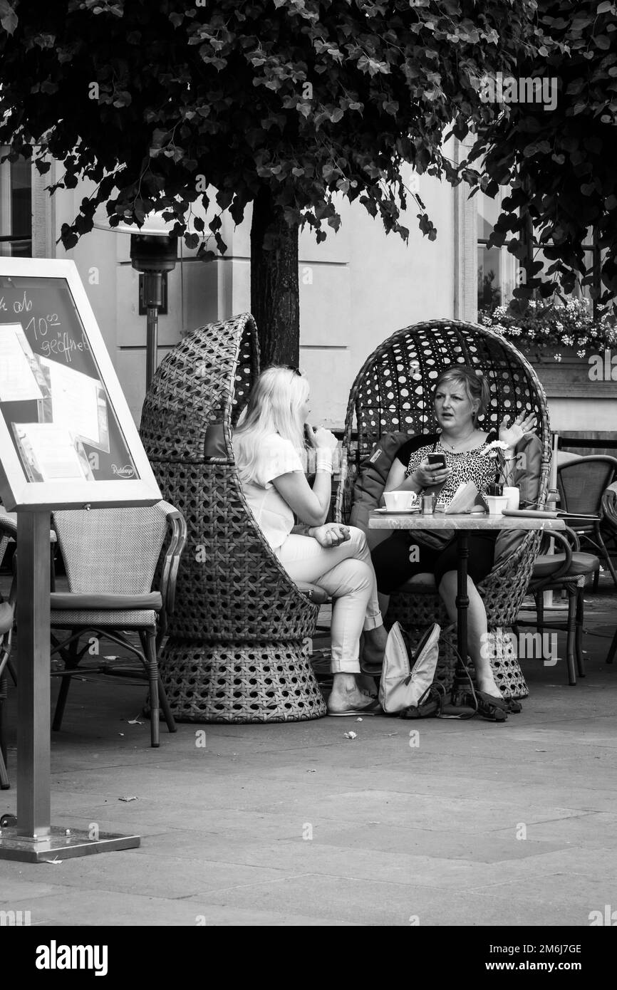 Les gens qui apprécient les boissons et le déjeuner assis à l'extérieur dans des chaises en osier à l'ombre d'un arbre à Dresde, Saxe, Allemagne Banque D'Images