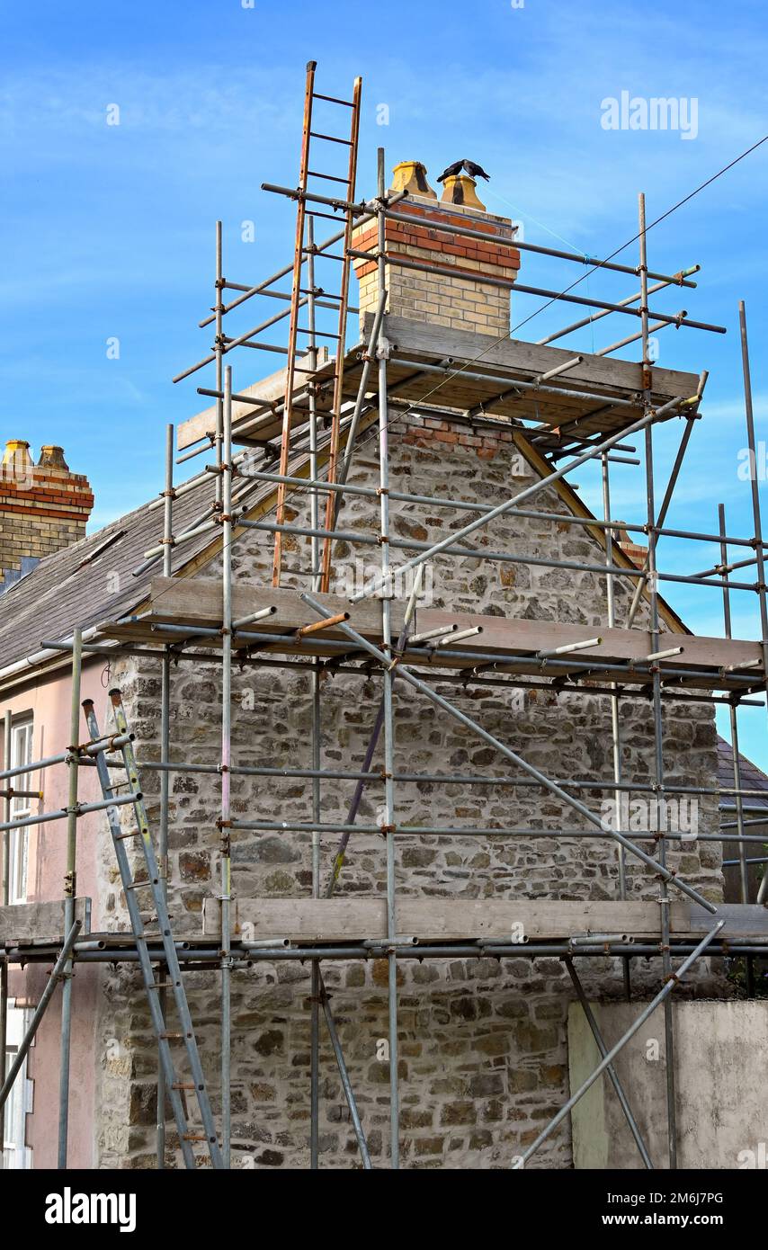 St Dogmaels, Pembrokeshire, pays de Galles - août 2022 : échafaudage attaché à une maison pour les reapares à son toit et sa cheminée. Banque D'Images St Dogmaels, Pembrokeshire, pays de Galles - août 2022 : échafaudage attaché à une maison pour les reapares à son toit et sa cheminée. Banque D'Images