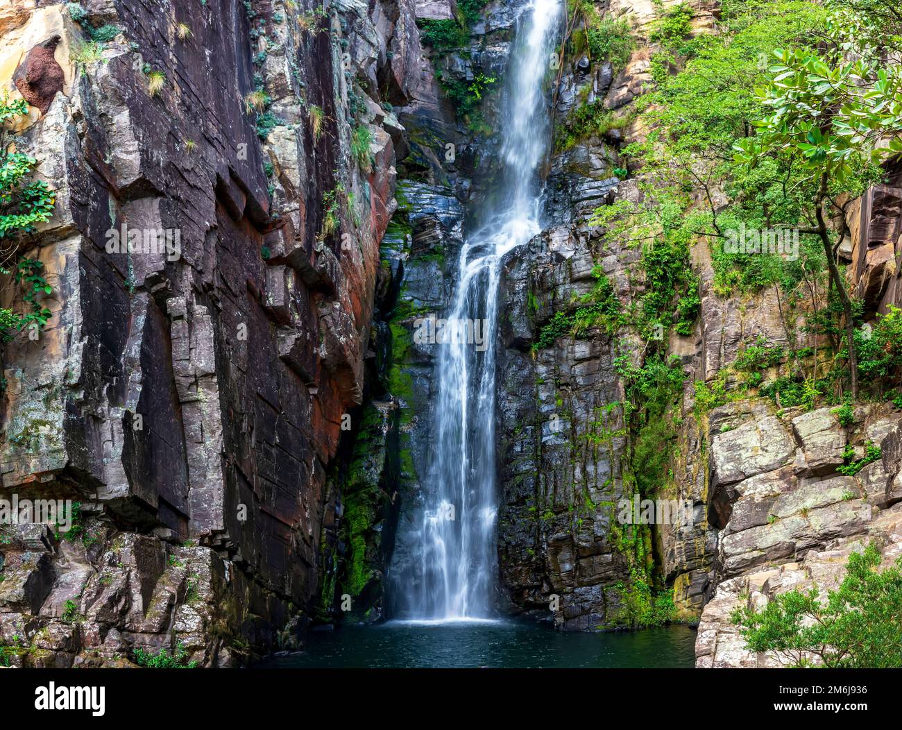 Cascade appelée Vau da Noiva entre les roches couvertes de mousse et la végétation Banque D'Images