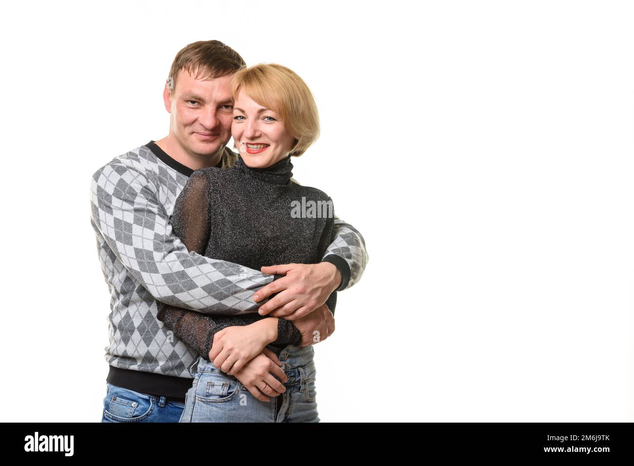 Portrait d'un jeune couple, un homme embrassant une femme, isolé sur un fond blanc Banque D'Images