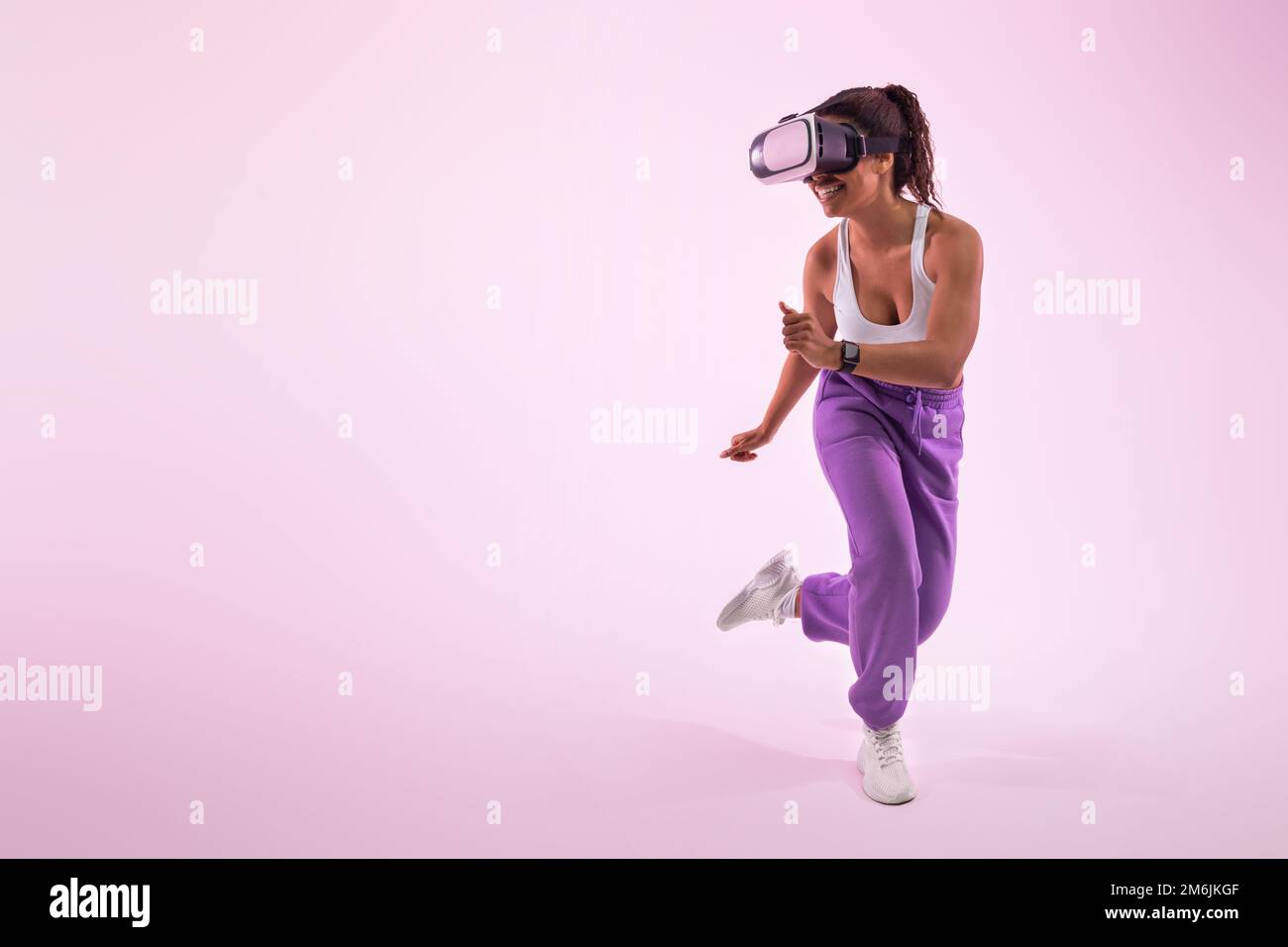 Découvrir le métaverse. Jeu de femme afro-américaine avec lunettes de réalité virtuelle, fond rose, espace libre Banque D'Images