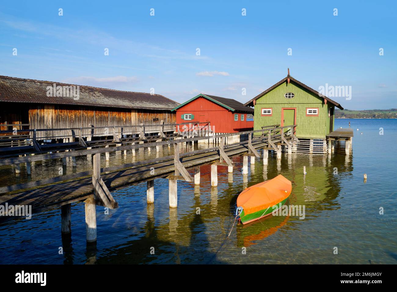 Une longue jetée en bois menant aux maisons de bateau colorées sur le lac Ammersee dans le village de pêcheurs allemand Schondorf (Ammersee, Allemagne) Banque D'Images