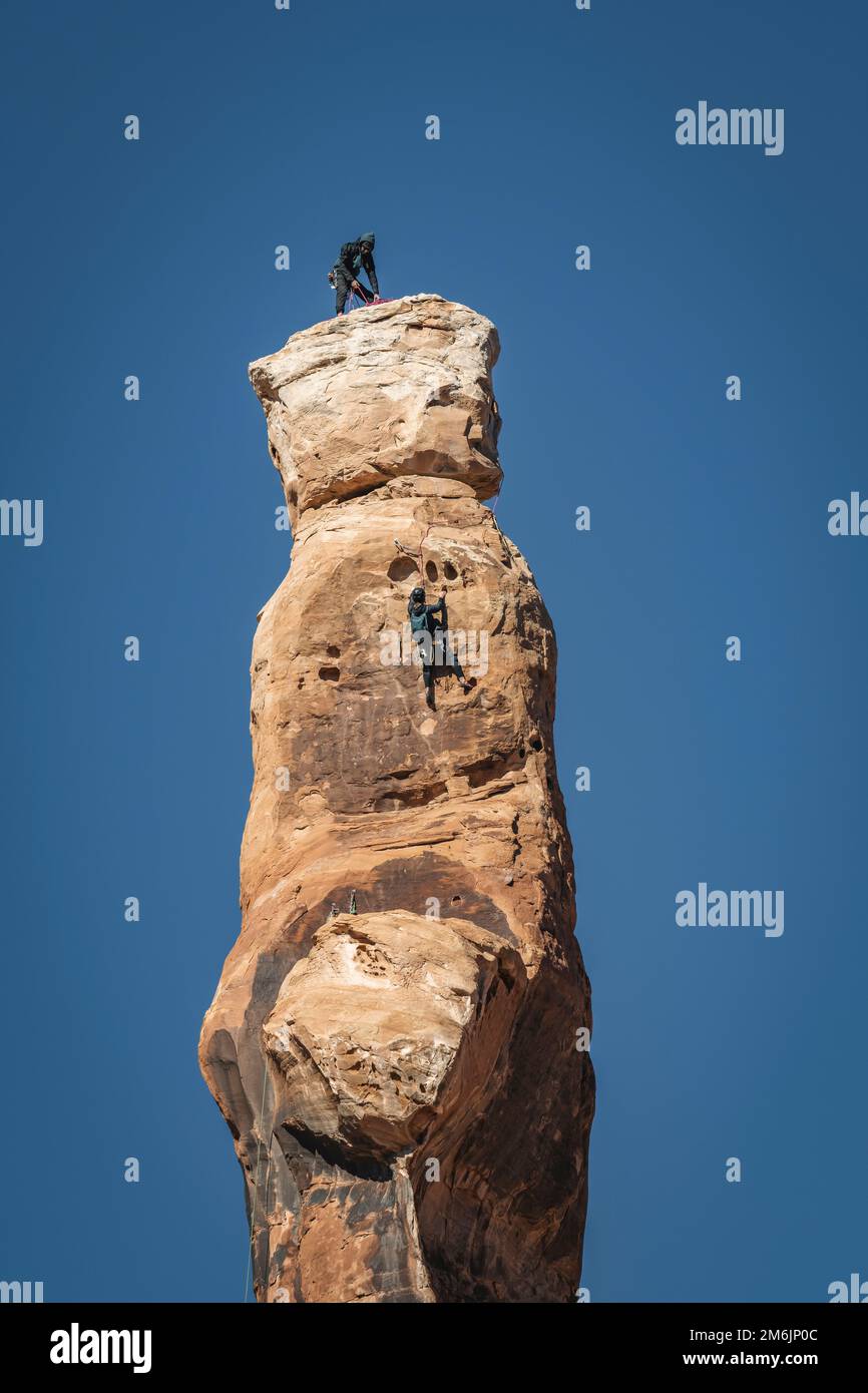 Homme et femme grimpant sur le Bride Canyon contre un ciel dégagé Banque D'Images