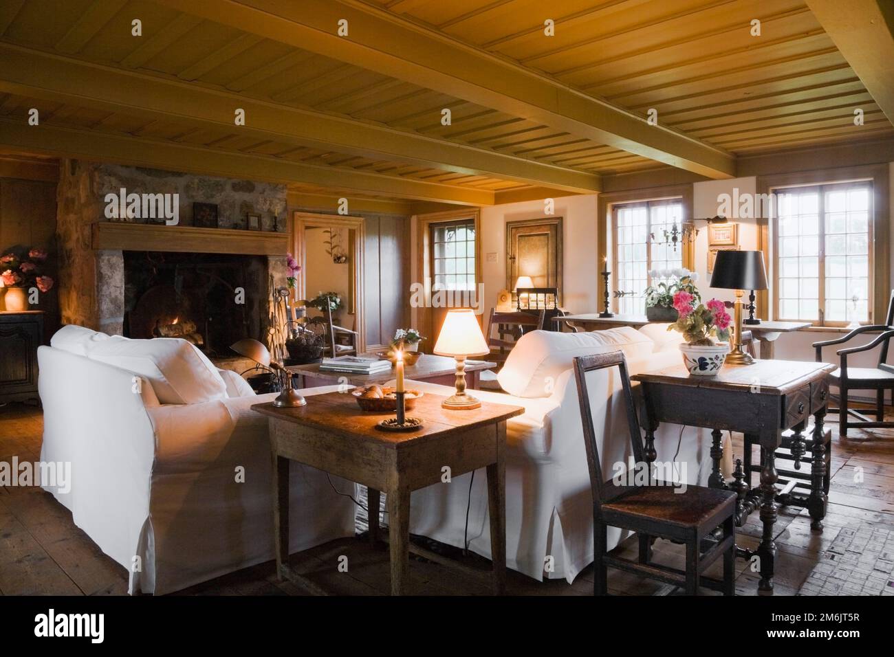 Canapés capitonnés en tissu blanc dans la salle de séjour à l'intérieur de l'ancienne maison de style cottage régime français de 1752. Banque D'Images