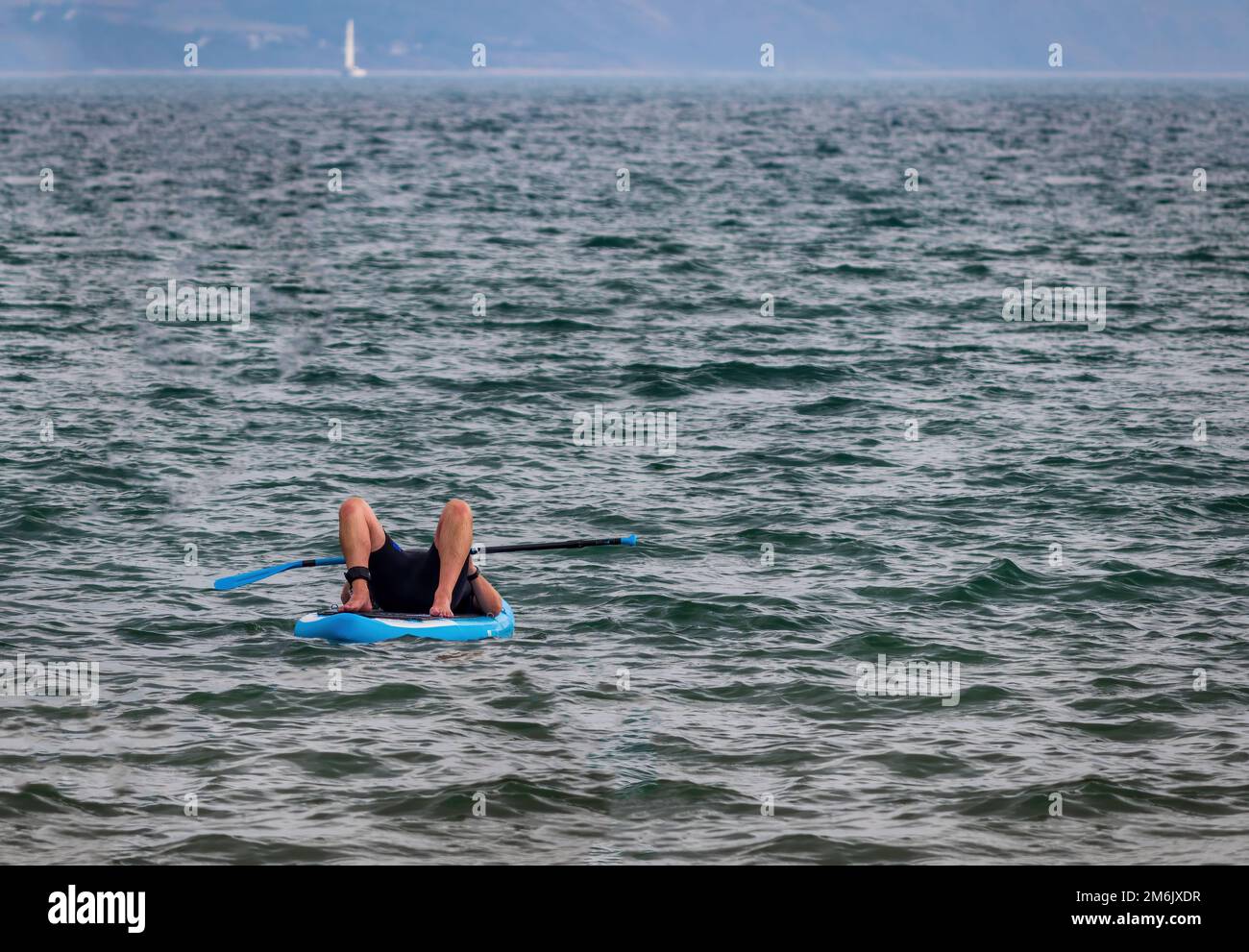 Homme allongé sur un paddle-board au bord de la plage de Weymouth Dorset  England Photo Stock - Alamy