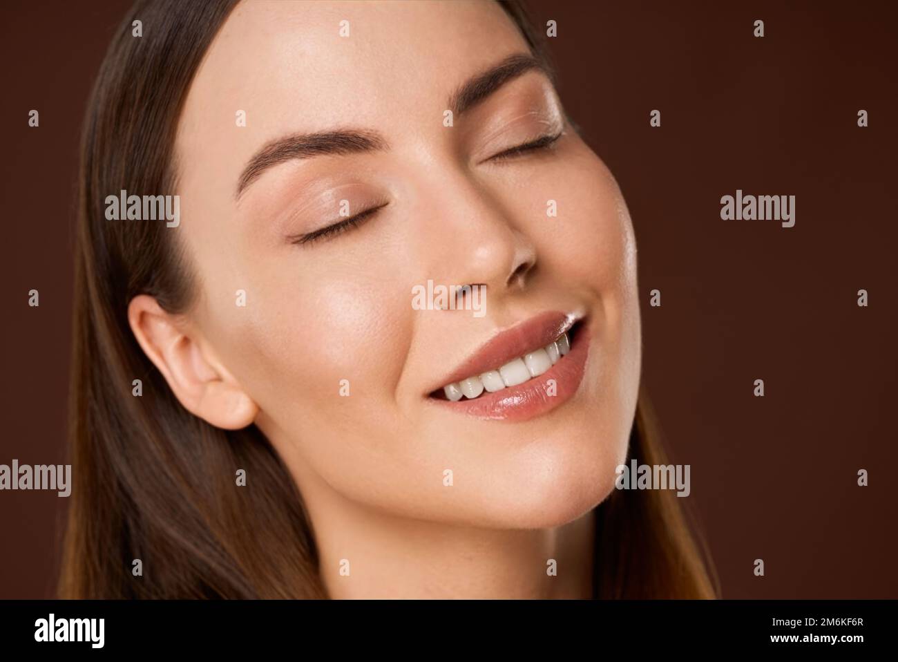 Femme souriante avec maquillage naturel et yeux fermés Banque D'Images