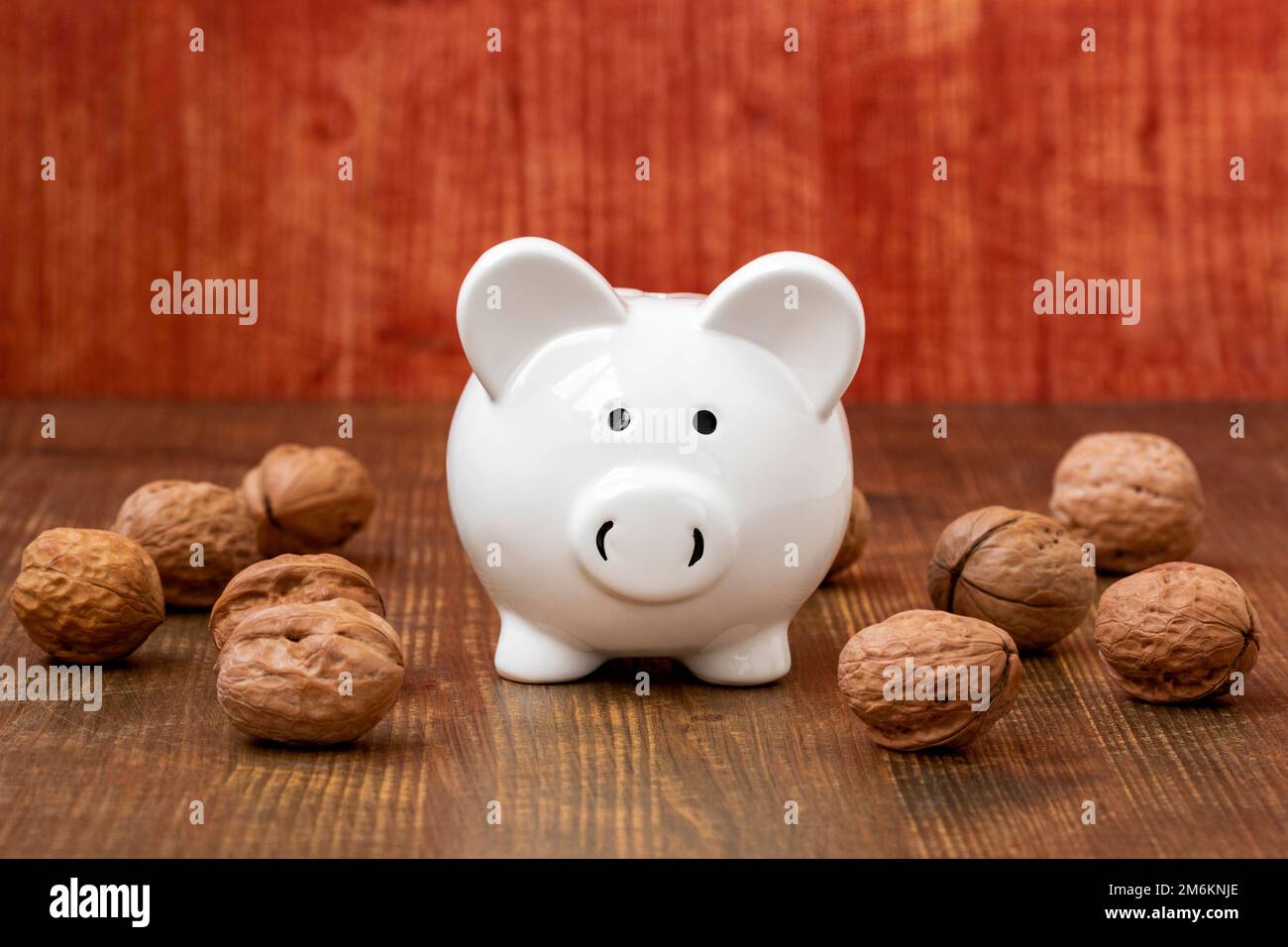 Banc de porc en céramique et noix sur fond en bois Banque D'Images