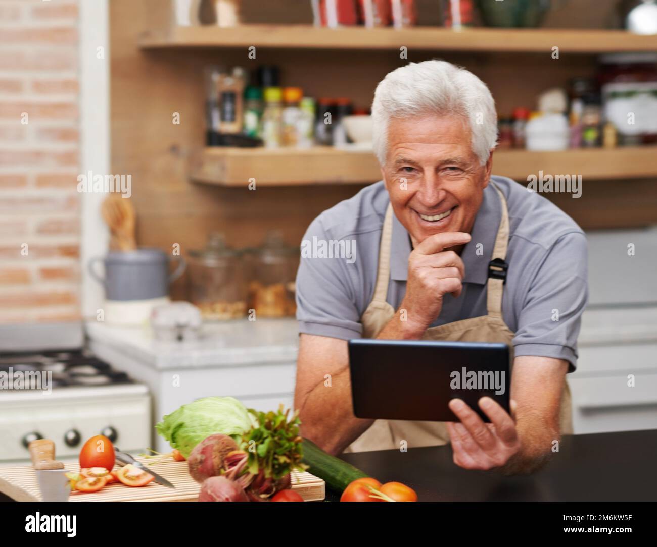 Cuisiner devient un jeu d'enfant. Portrait d'un homme âgé souriant directement à l'appareil photo. Banque D'Images