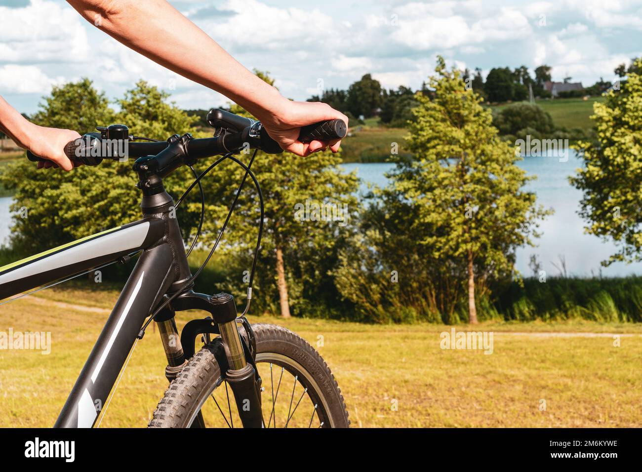 Femme tenant un guidon de vélo sur fond de nature Banque D'Images