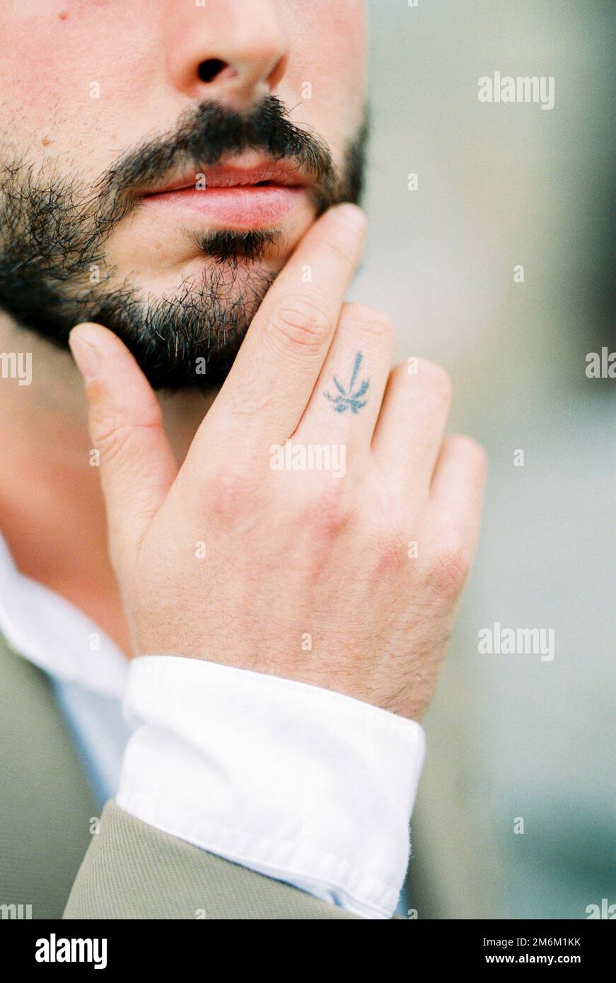 Un homme avec une barbe touche son menton avec ses doigts. Gros plan Banque D'Images