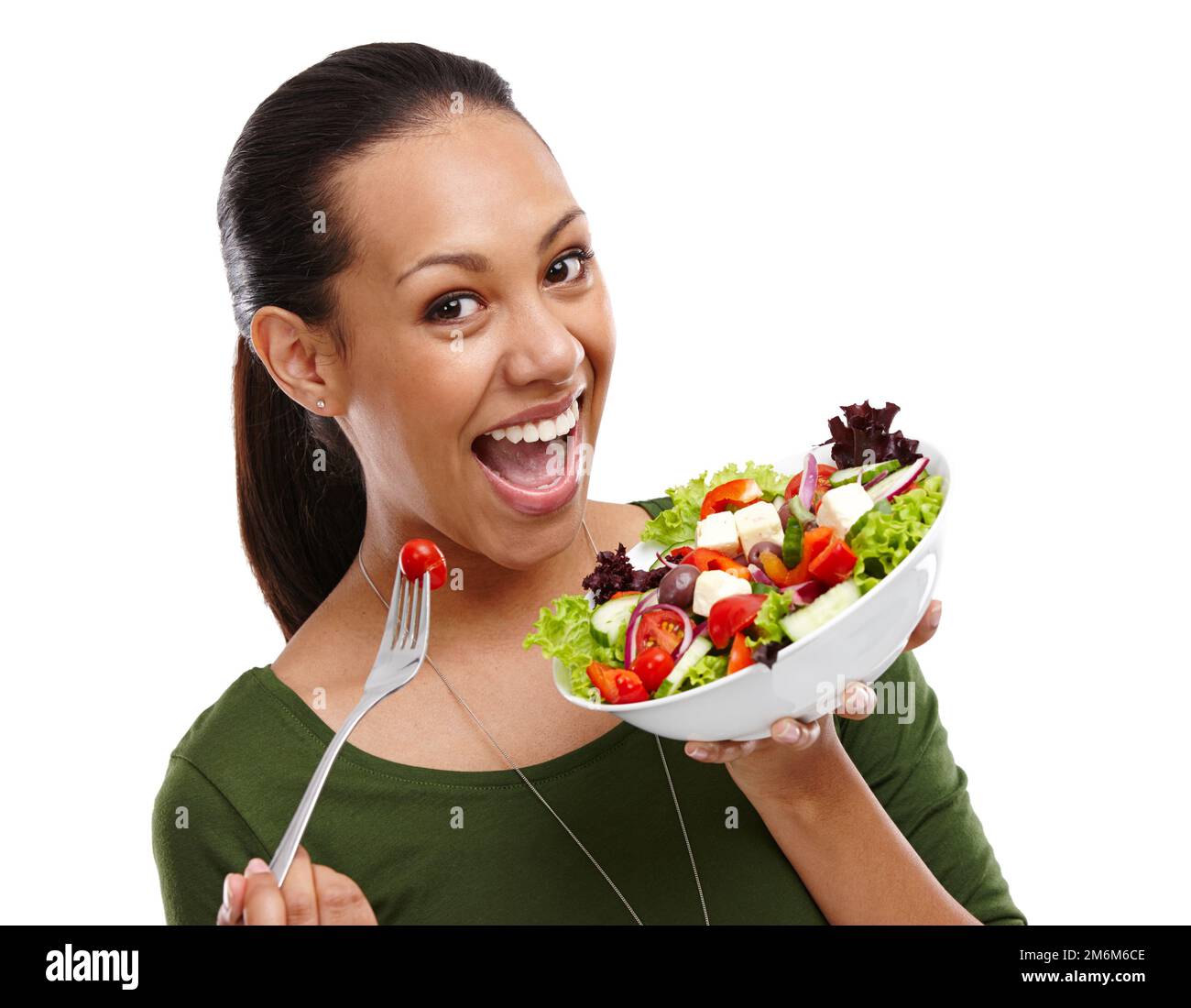 Obtenez cette bonté en vous. Portrait d'une jeune femme attrayante mangeant un bol de salade isolé sur blanc. Banque D'Images