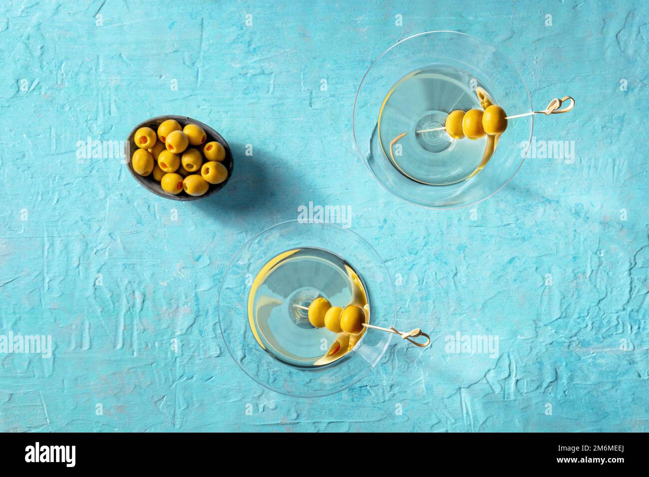 Martini, deux verres aux olives épicées, sur fond bleu Banque D'Images