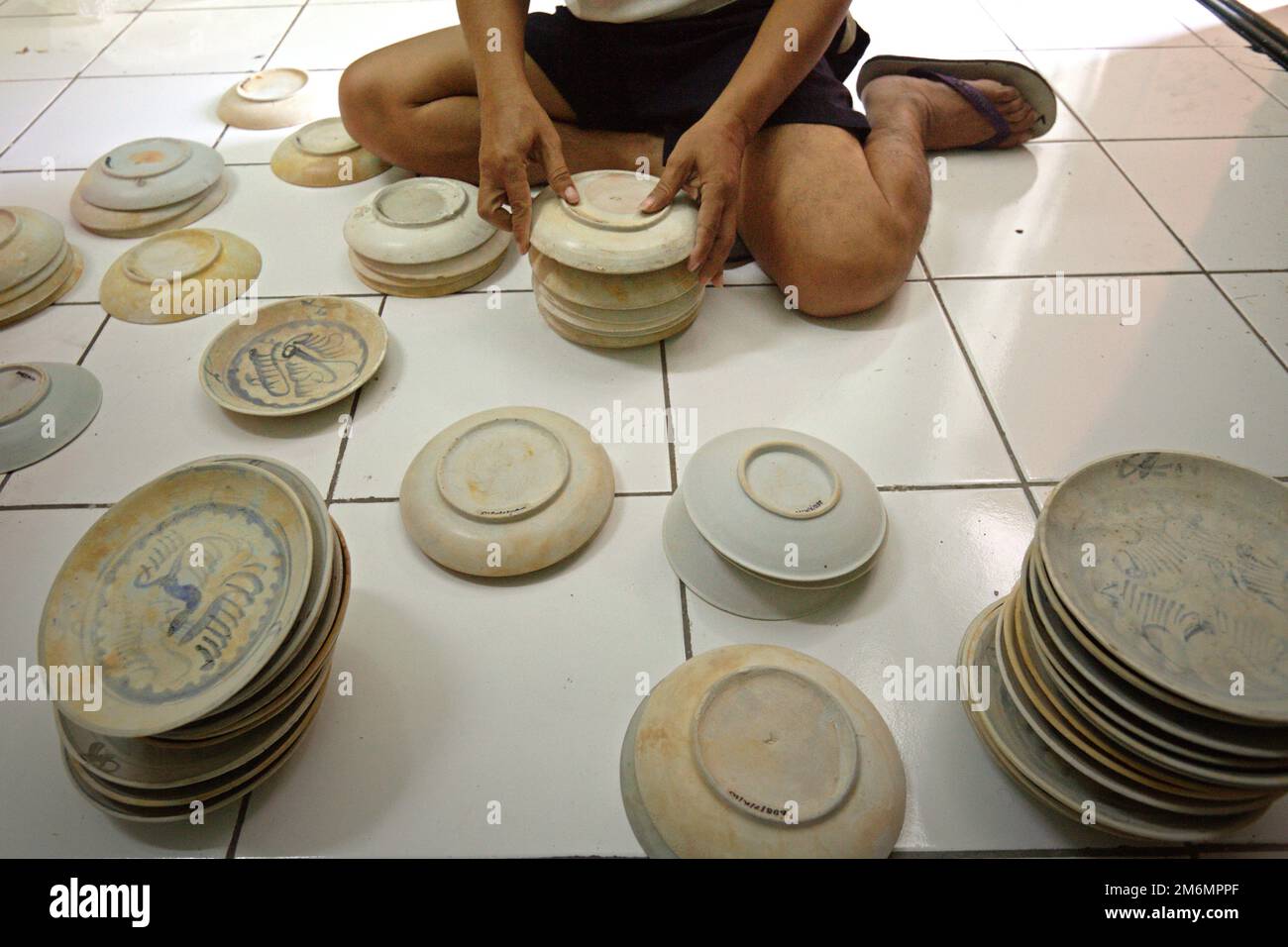 Archéologue marintime organisant des céramiques chinoises anciennes non arrosées du IXe-Xe siècle Cirebon naufrage trouvé en 2003 dans la mer de Java au nord de Cirebon, Java Ouest, Indonésie. Photographié dans la salle de stockage de la Direction de l'Archéologie subaquatique, Ministère indonésien de la culture et du Tourisme à Jakarta, Indonésie. Banque D'Images