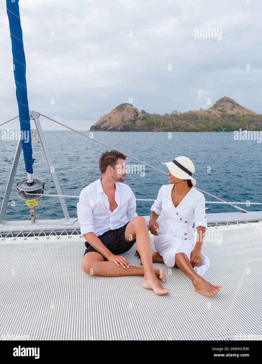 Couple hommes et femme regardant le coucher du soleil depuis un bateau à voile dans la mer des Caraïbes Sainte-Lucie ou Sainte-Lucie Banque D'Images