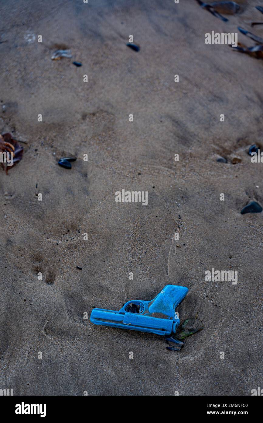 jouet pistolet en plastique bleu sur une plage de sable dans le nord du yorkshire, royaume-uni Banque D'Images