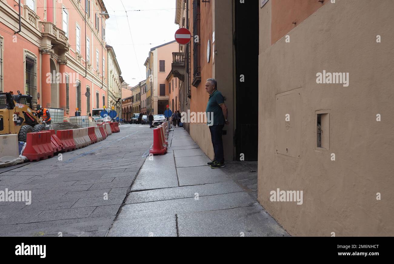 BOLOGNE, ITALIE - VERS SEPTEMBRE 2022 : Umarell homme en âge de prendre sa retraite regardant le chantier de construction de travaux routiers avec les mains jointes derrière son dos et offre Banque D'Images
