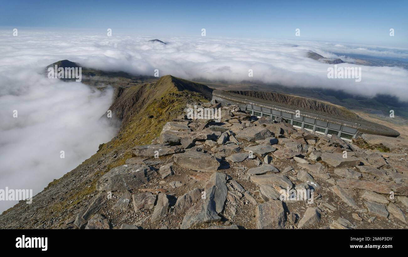 Une vue aérienne du sommet rocailleux de Snowdon dans les nuages blancs moelleux Banque D'Images