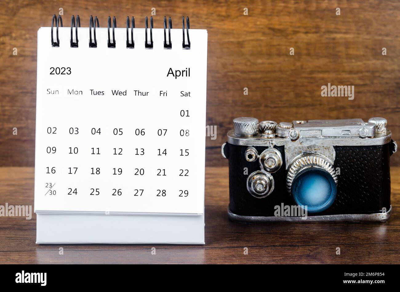 Avril 2023 Calendrier mensuel de bureau pour l'organisateur de planifier 2023 ans avec un appareil photo vintage sur fond de table. Banque D'Images