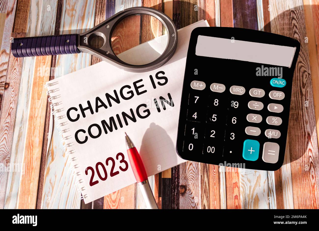 le bloc-notes avec le mot change vient en 2023 sur un arrière-plan vintage avec une loupe, une calculatrice et un stylo Banque D'Images