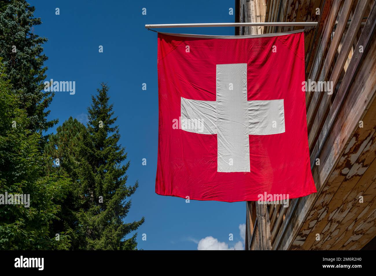 Drapeau suisse. Drapeau suisse suspendu sur le toit contre le ciel bleu. Un drapeau carré rouge avec une croix blanche au centre. Banque D'Images