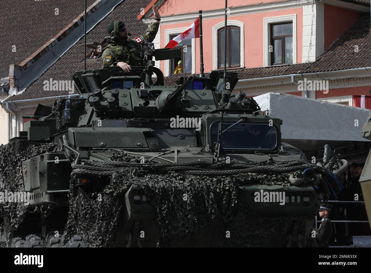 Un soldat de l’armée canadienne affecté au groupe de combat de l’OTAN pour la présence avancée s’enfile vers la foule alors que le véhicule roule sur la route du défilé sur la place Oskaras Kalpaka à Saldus, en Lettonie, lors de la célébration du jour de l’indépendance, à 4 mai 2022. Le jour du rétablissement de l'indépendance de la Lettonie marque la date en 1990 où le Conseil suprême de Lettonie a adopté la Déclaration sur le rétablissement de l'indépendance, qui a amorcé la transition du régime soviétique au renouvellement complet de l'indépendance dans l'État Baltique. La date est commémorée par un défilé militaire mettant en vedette ses alliés de l'OTAN. Banque D'Images