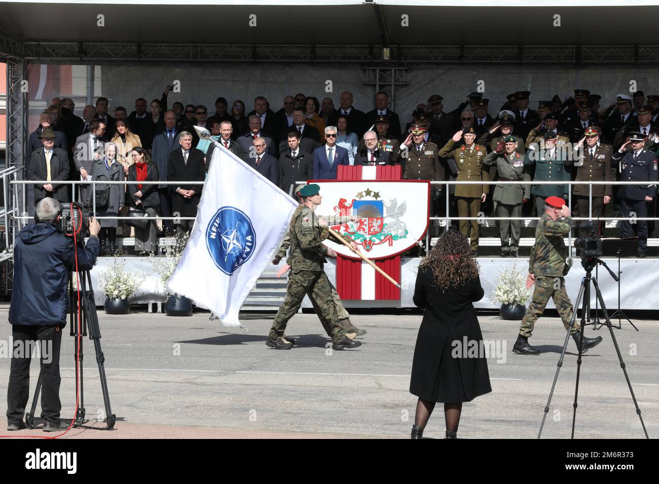 Un soldat polonais, affecté au groupe de combat renforcé de la présence avancée de l’OTAN, détient le drapeau de l’unité d’intégration de la force de l’OTAN alors qu’il marche devant le col, sur la place Oskaras Kalpaka, à Saldus, en Lettonie, lors de la célébration du jour de la restauration de l’indépendance, à 4 mai 2022. Le jour du rétablissement de l'indépendance de la Lettonie marque la date en 1990 où le Conseil suprême de Lettonie a adopté la Déclaration sur le rétablissement de l'indépendance, qui a amorcé la transition du régime soviétique au renouvellement complet de l'indépendance dans l'État Baltique. La date est commémorée par un FE de parade militaire Banque D'Images