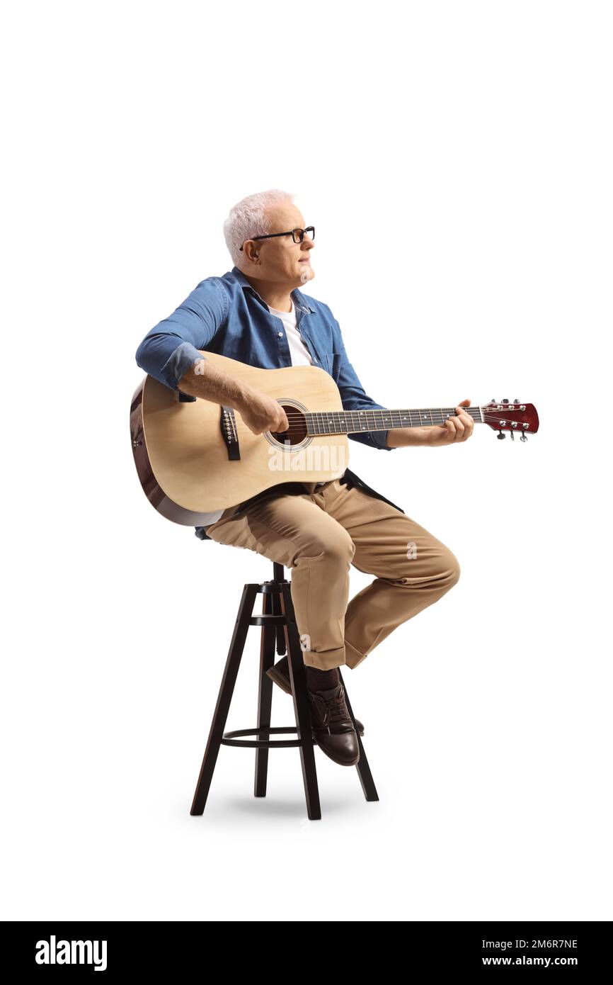 Musicien mature assis sur une chaise jouant une guitare acoustique et  regardant le côté isolé sur fond blanc Photo Stock - Alamy