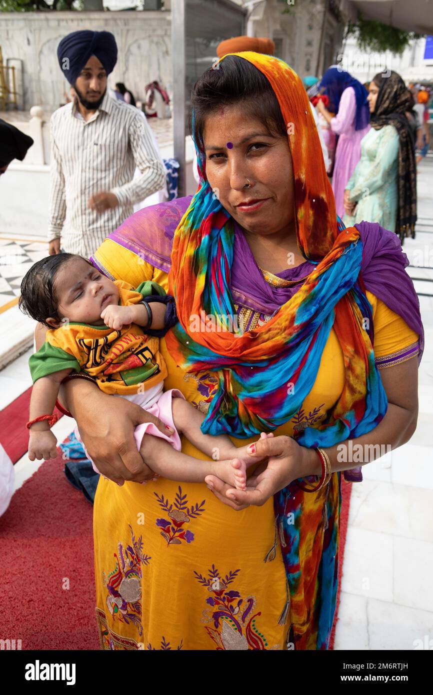 Femme indienne en robes indiennes et bébé au Hari Mandir ou Temple d'Or, Amritsar, Punjab, Inde Banque D'Images