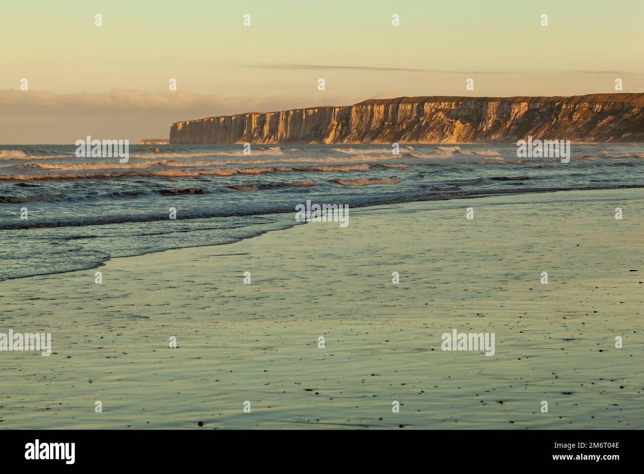 Le soleil se couche sur les falaises imposantes de Flamborough Head, vues depuis Hunmanby Sands, Filey, North Yorkshire Banque D'Images