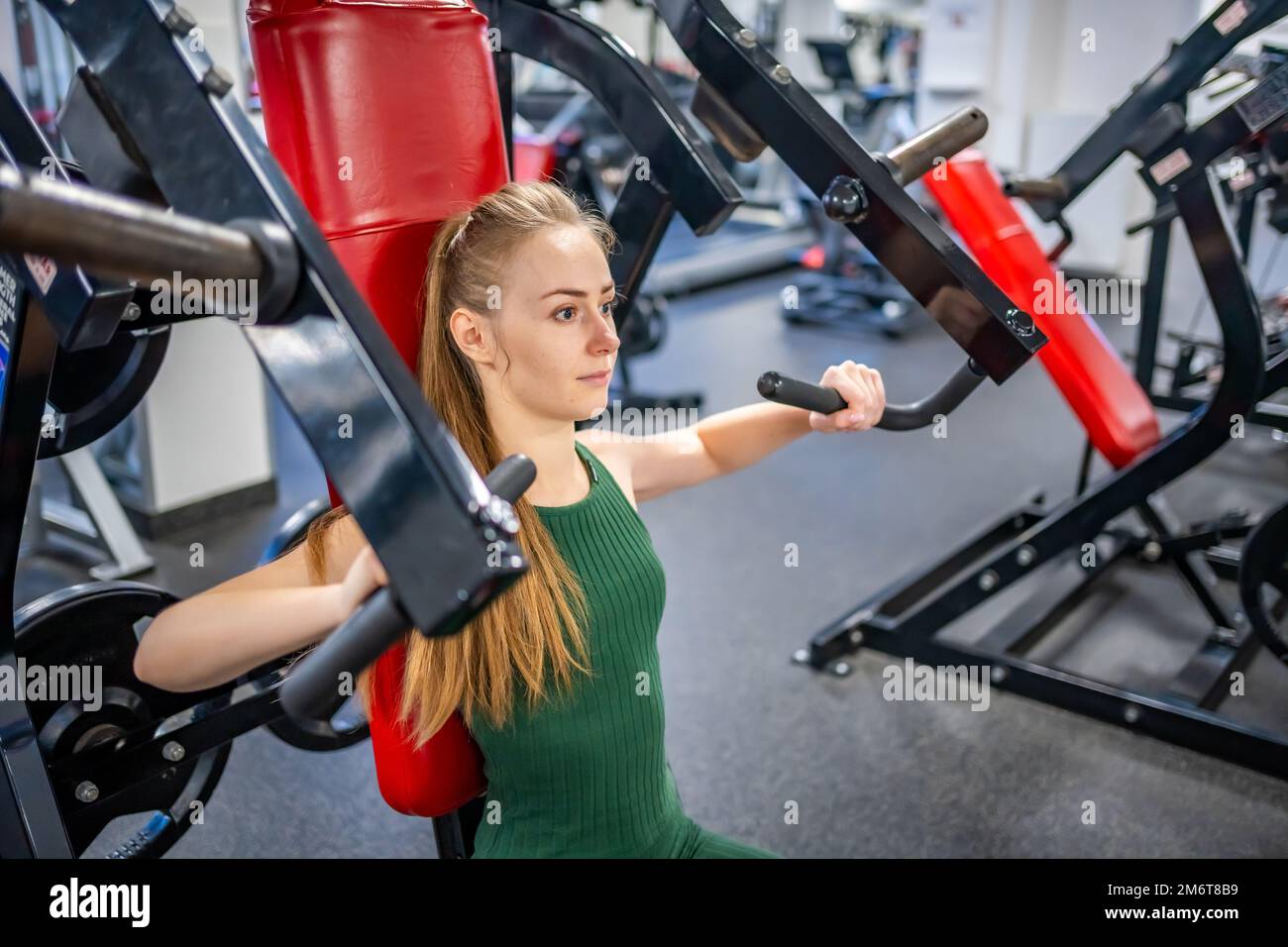 Une jeune femme s'entraîner sur un équipement de fitness à la salle de gym. Concept de santé, de sport et d'entraînement Banque D'Images