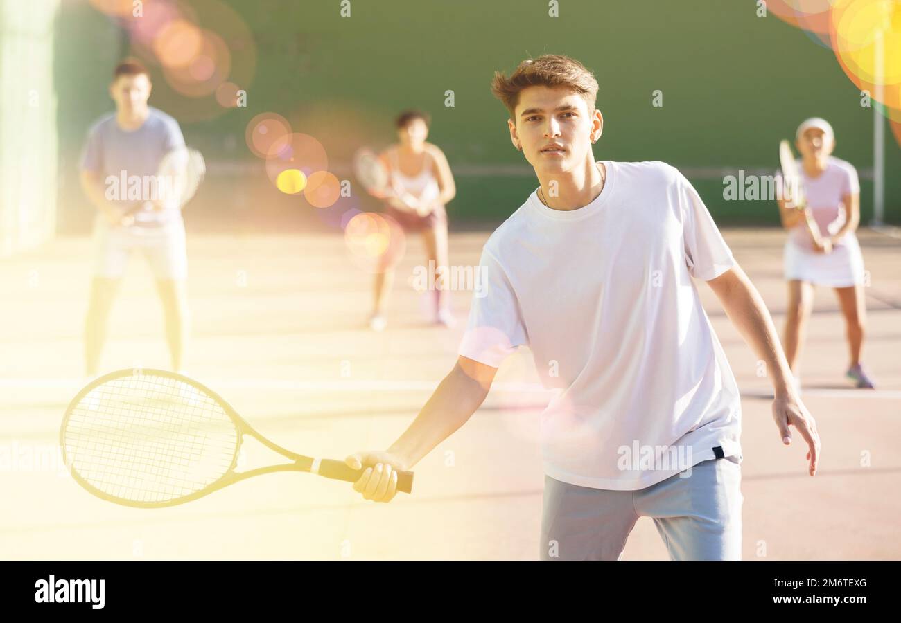 Un sportif masculin se prépare à frapper le ballon avec une raquette. Frontenis sur un terrain de plein air Banque D'Images