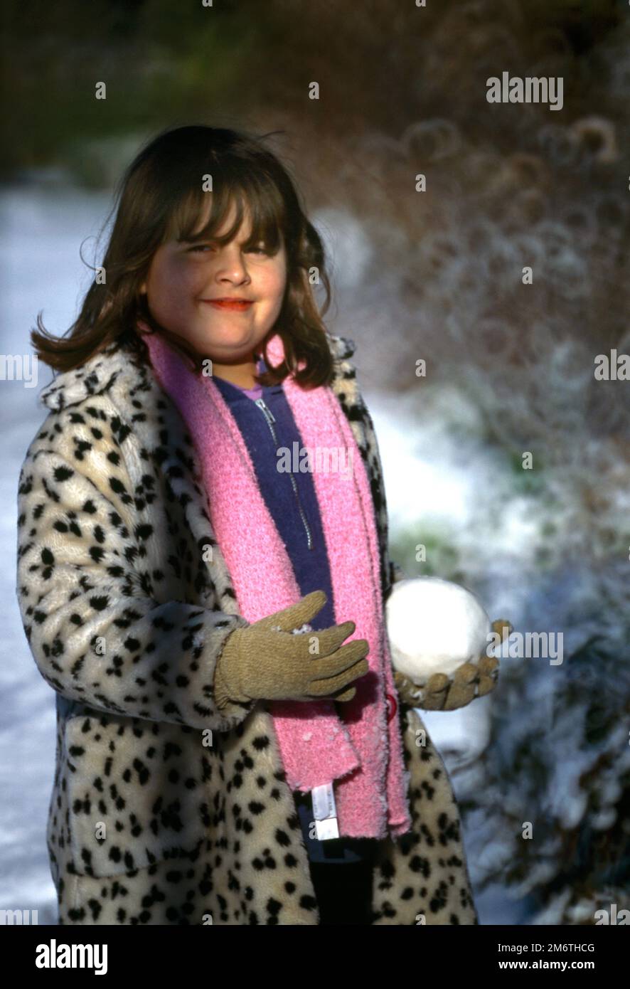 Enfant tenant un grand Snowball dans le Surrey d'hiver en Angleterre Banque D'Images