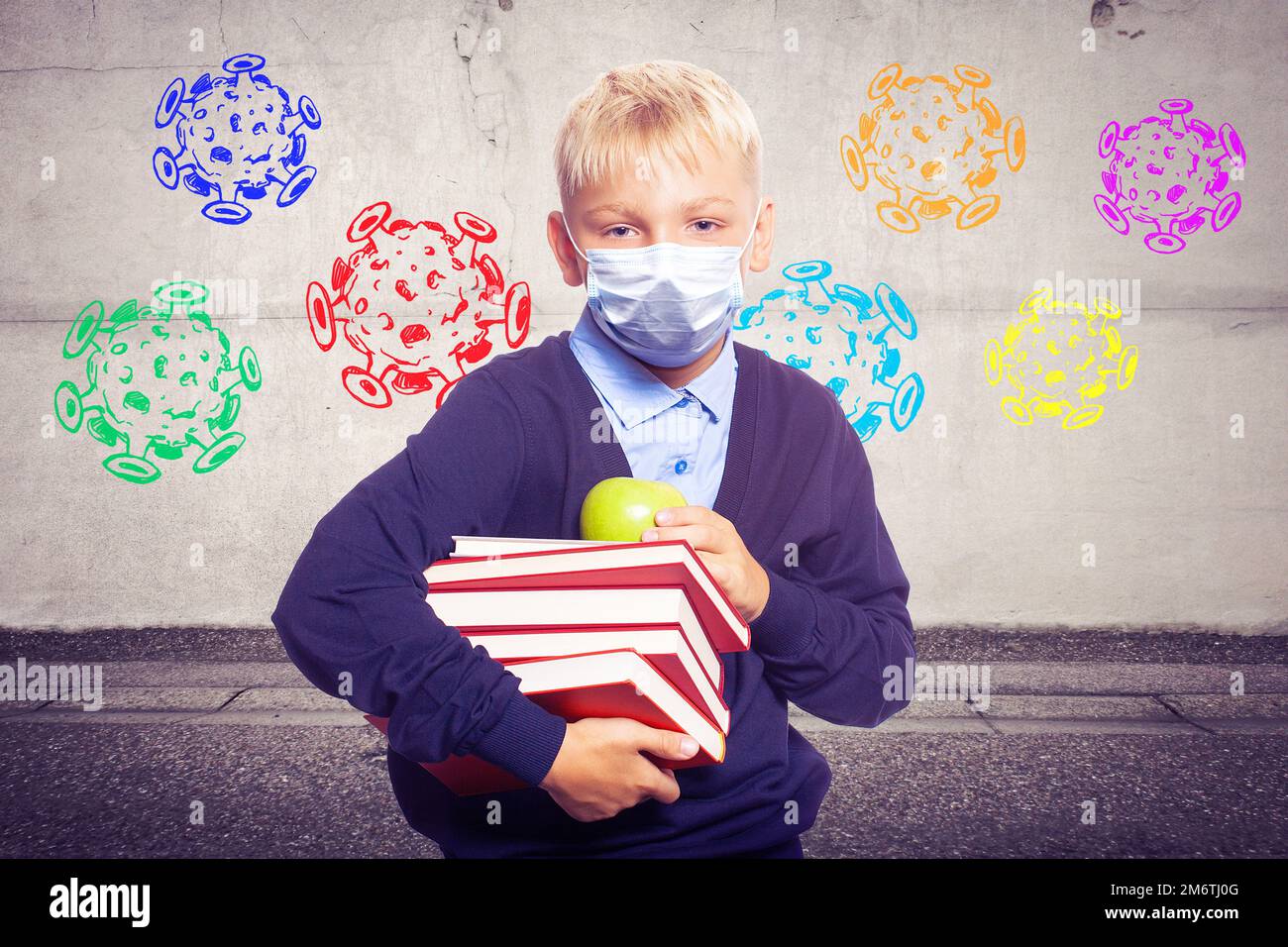 Jeune garçon avec un masque de protection contre le virus corona à l'école. Banque D'Images