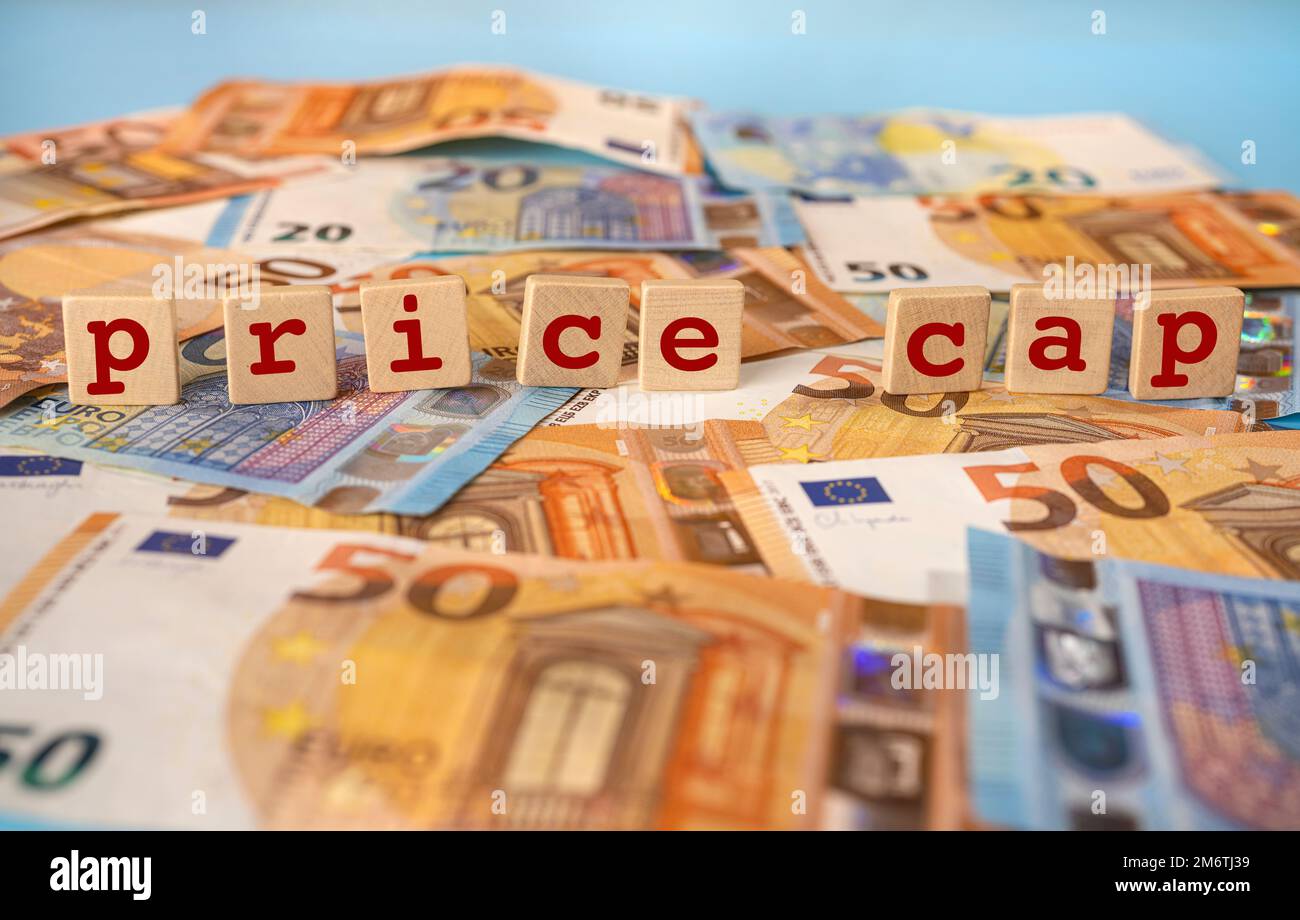 L'expression Price Cap écrit sur des chevilles en bois sur un fond de billets en euros Banque D'Images