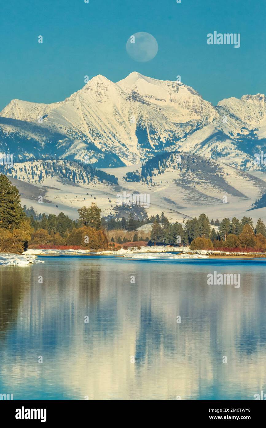 Lune qui s'élève au-dessus de la rivière Flathead et mission montagne en hiver près de Dixon, Montana Banque D'Images