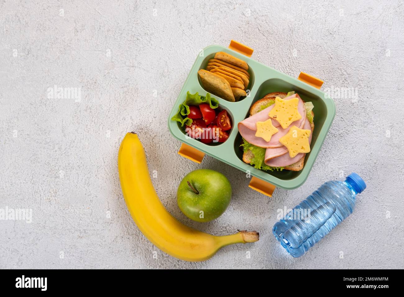 Boîte repas saine avec sandwich et salade sur la table. Banane, pomme et une bouteille d'eau. Retour à l'école Banque D'Images