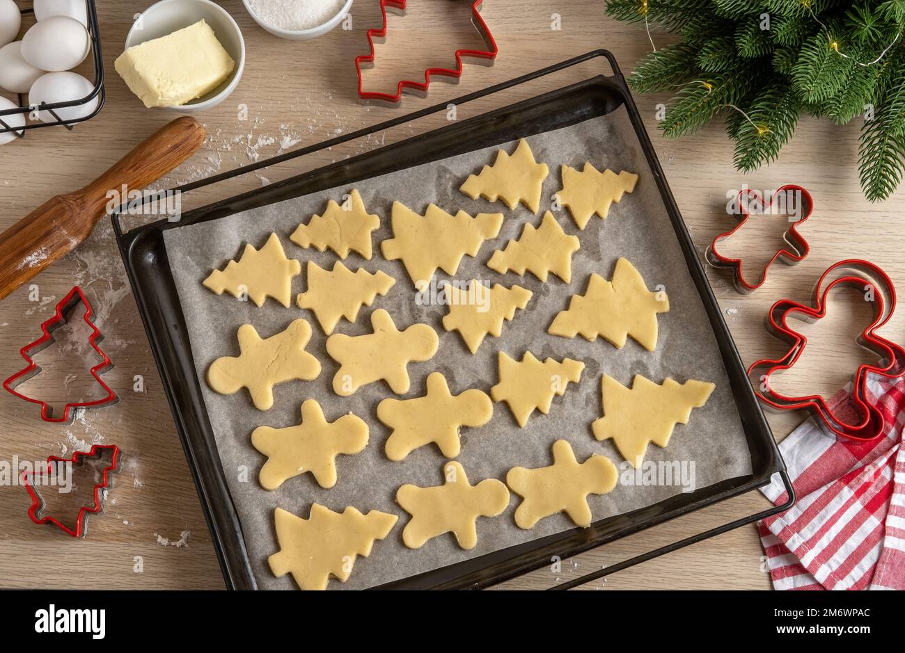 Moule rempli de biscuits de pain d'épice non cuits. Noël bonhomme de pain d'épice et sapins sur la poêle. Vue de dessus. Recette traditionnelle maison. Banque D'Images