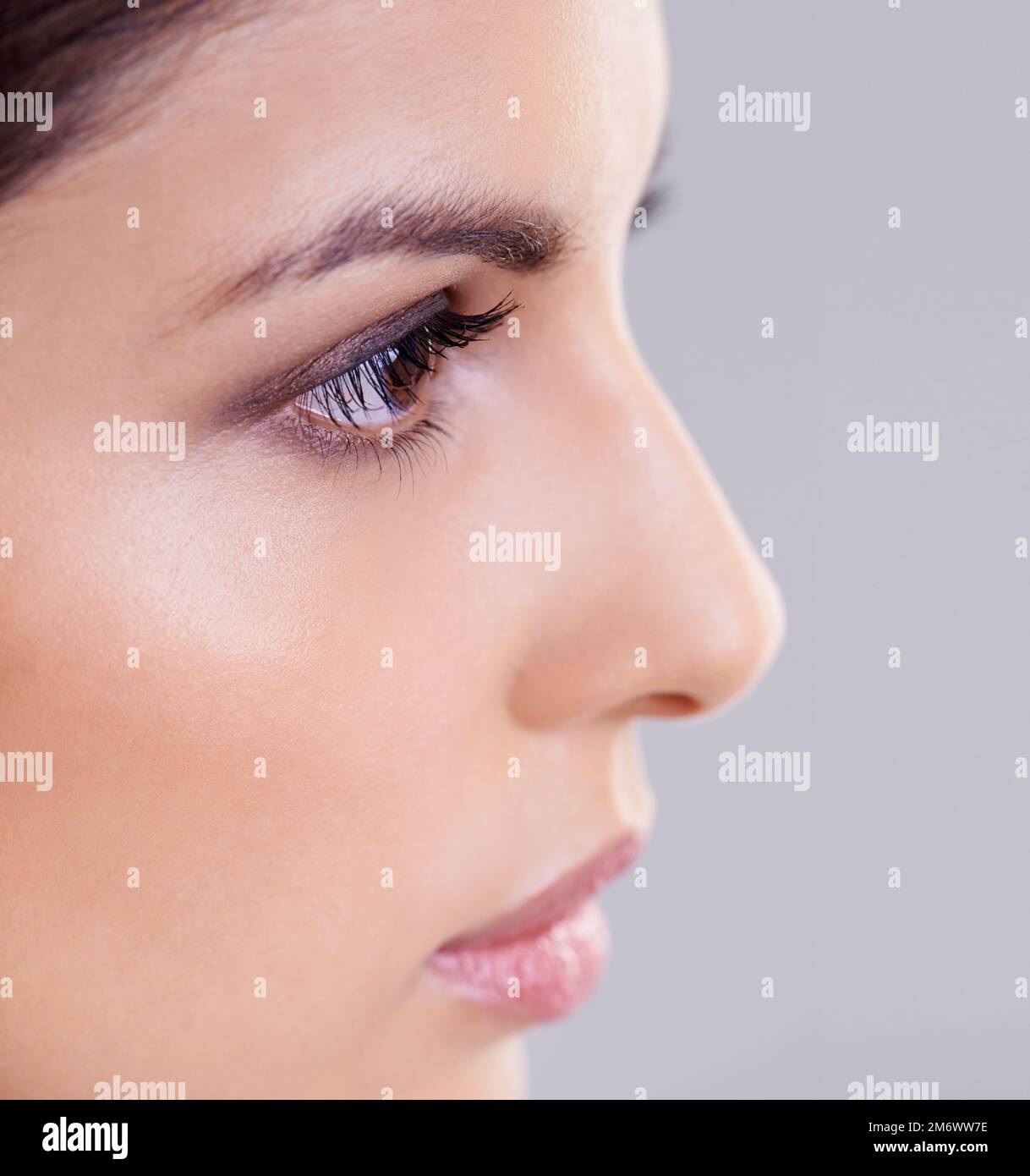 Absolument radieux. Photo studio d'une belle femme brune sur fond gris. Banque D'Images