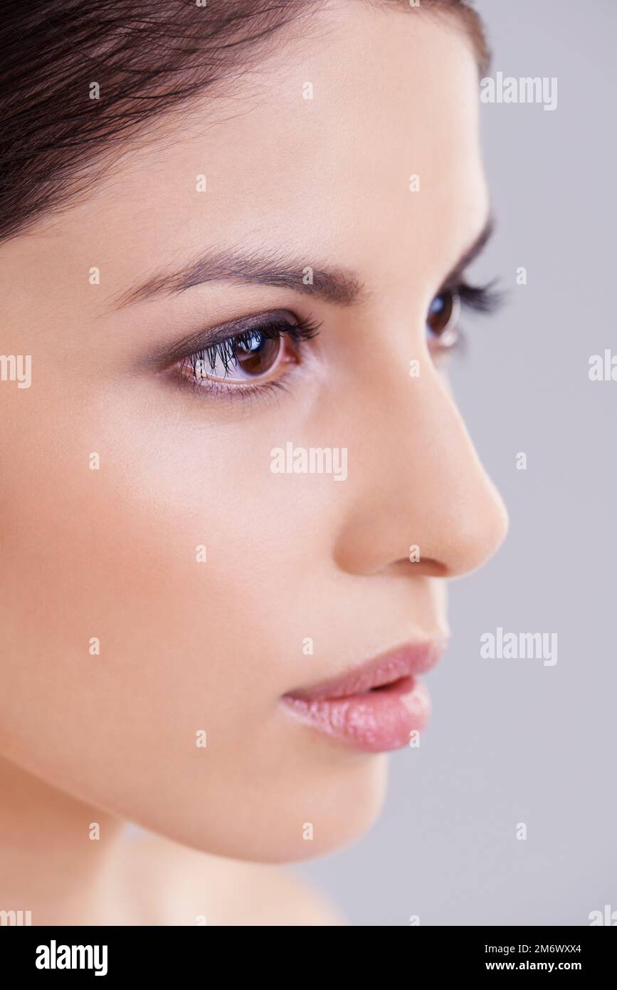 Tout sur elle est la perfection. Photo studio d'une belle femme brune sur fond gris. Banque D'Images