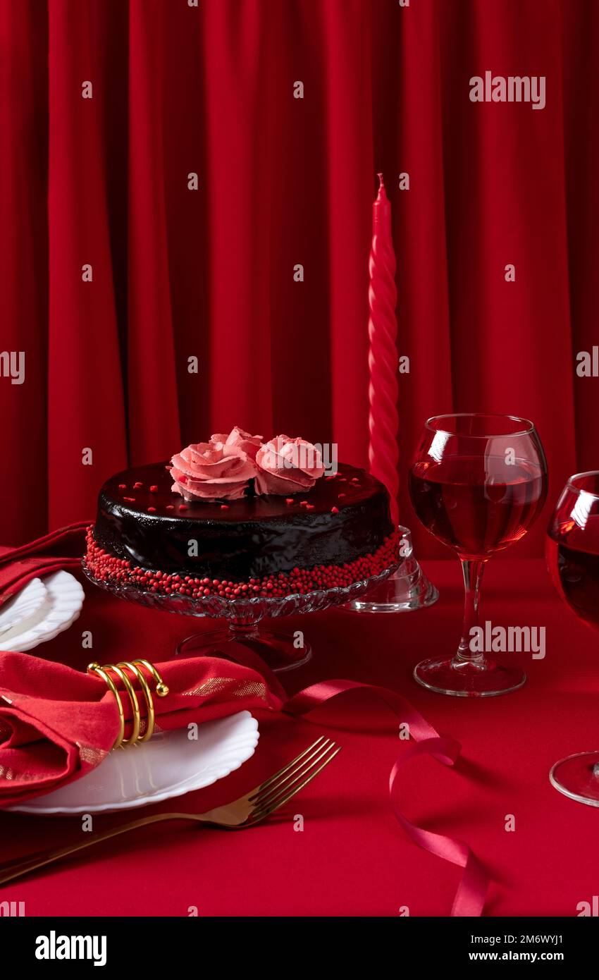 Table romantique avec vaisselle blanche et serviettes rouges, vin et bougies. Concept Saint Valentin ou dîner romantique. Romain Banque D'Images