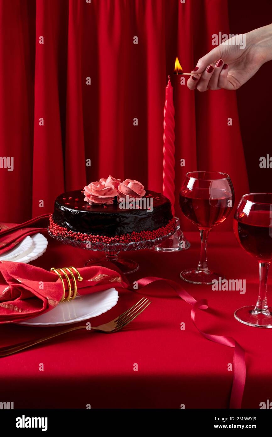 Table romantique avec vaisselle blanche et serviettes rouges, vin et bougies. Concept Saint Valentin ou dîner romantique. Romain Banque D'Images