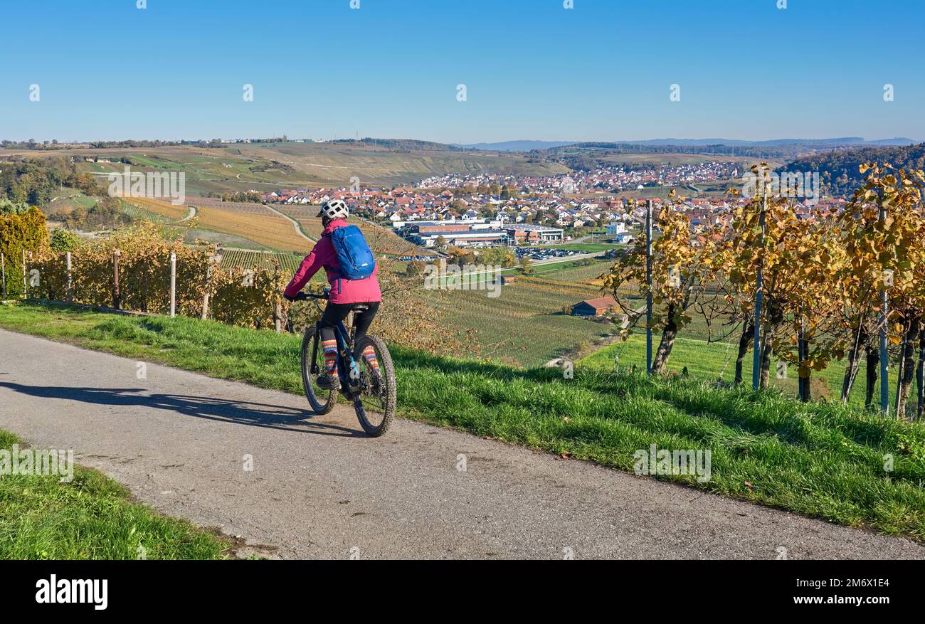 Femme avec vélo électrique dans les vignobles d'automne Banque D'Images