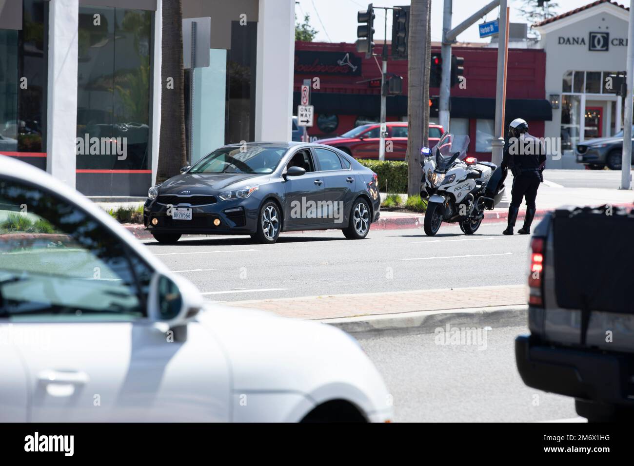 Costa Mesa, Californie, Etats-Unis - 20 mars 2022: Un policier de la cop de moto tire sur un automobiliste pendant un arrêt de circulation. Banque D'Images