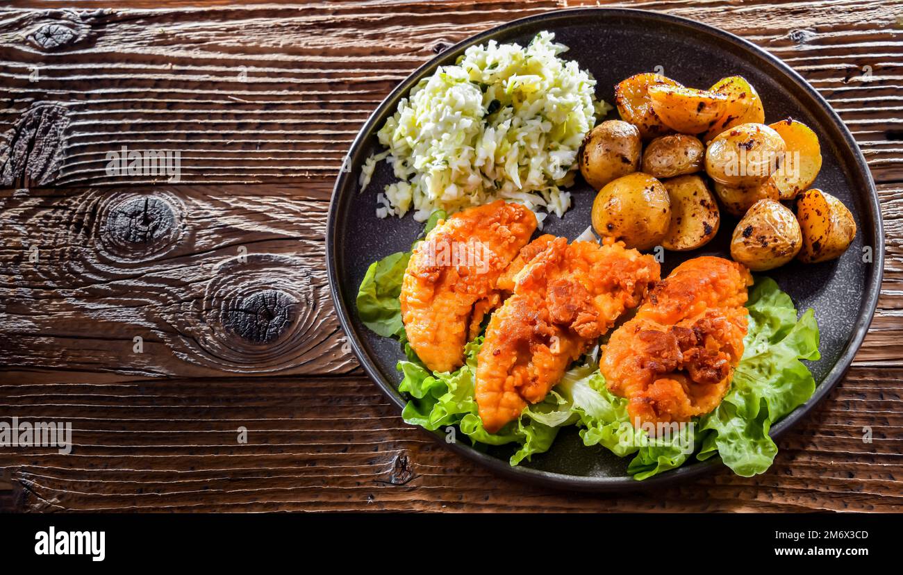 Côtelettes de poulet panées servies avec des pommes de terre et du chou. Banque D'Images