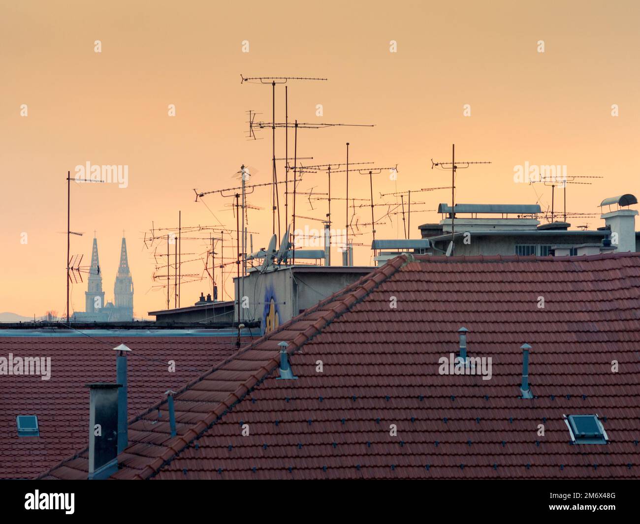 Une image des silhouettes d'arbre et d'antenne tv sur le toit pendant le coucher du soleil à Zagreb en Croatie Banque D'Images