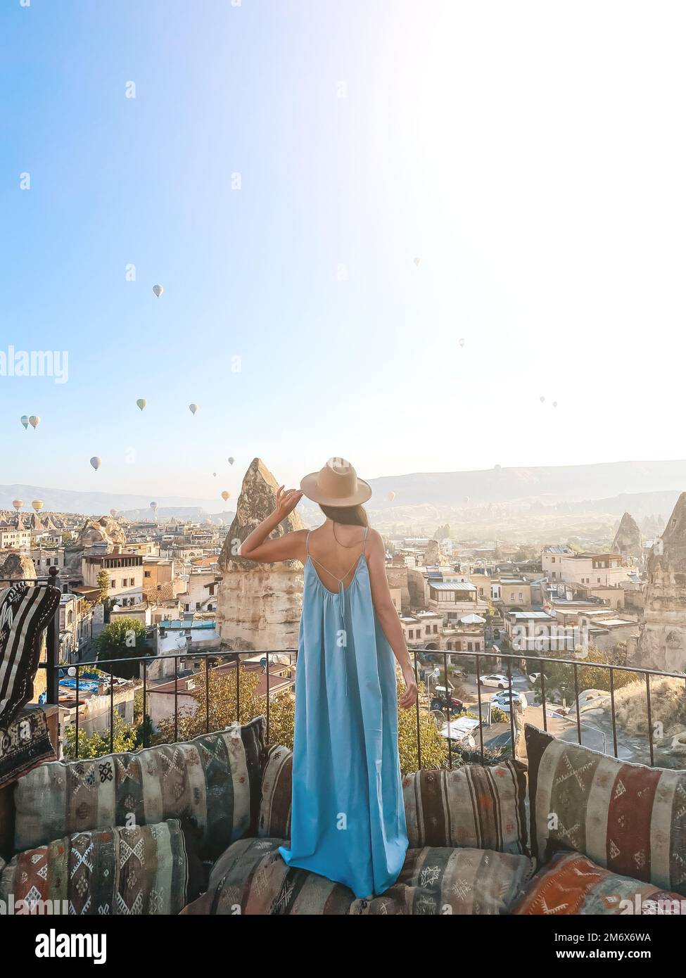 Jeune femme en robe sur le toit avec vue incroyable sur la Cappadoce en Turquie Banque D'Images