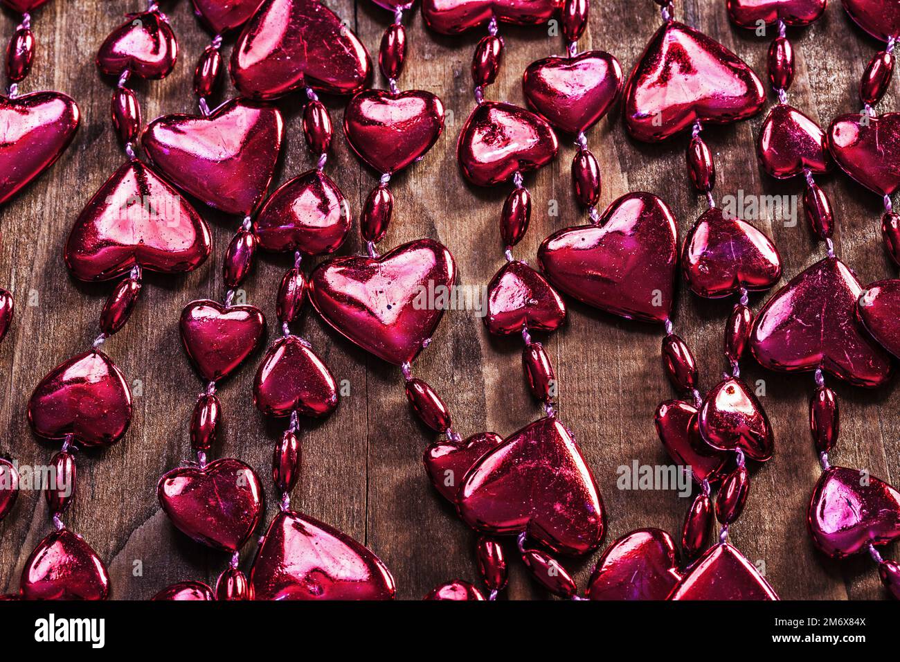 arrière-plan rouge valentines perles guirlande sur ancienne planche en bois version horizontale Banque D'Images