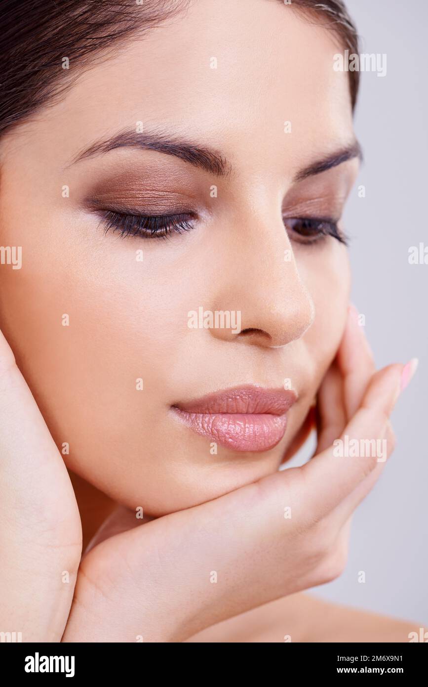 Une peau impeccable. Photo studio d'une belle femme brune sur fond gris. Banque D'Images