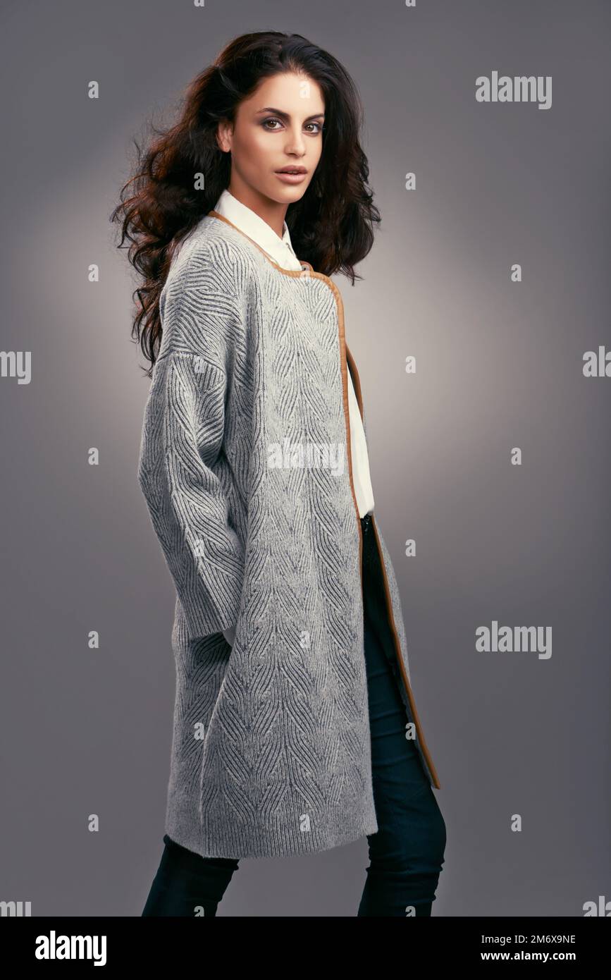 Elle met le style dans l'élégance. Photo studio d'une jeune femme élégamment habillée sur fond gris. Banque D'Images